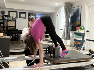 Standing Carriage Pull Reformer exercise with focus on deep core engagement. 